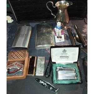 A COLLECTION OF FLASKS CIGARETTE LIGHTERSPOCKET KNIVES AND A LEATHER CIGARETTE HOLDER SOLD AS IS